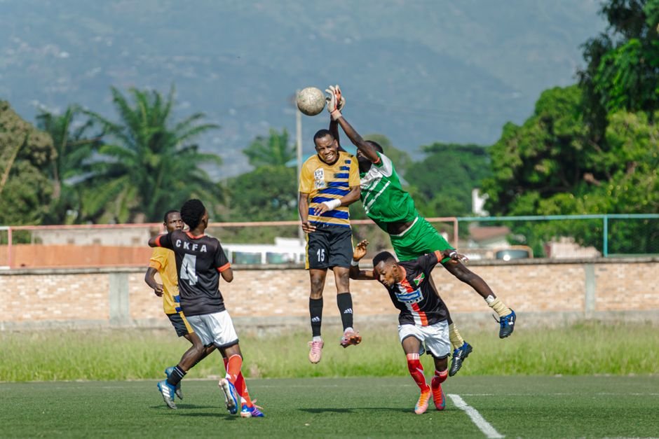 Intense soccer match with players competing to head the ball, showcasing skill and athleticism.