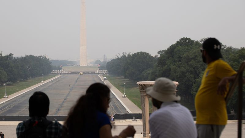 Hazy wildfire smoke obscures the skyline of a major US city under air quality alert